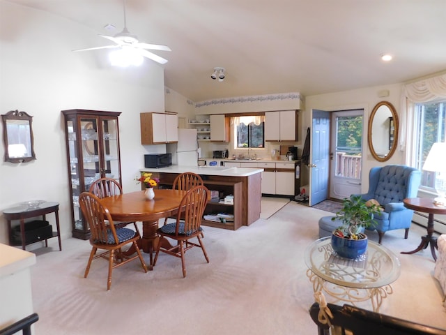 carpeted dining room featuring ceiling fan, a baseboard radiator, sink, and lofted ceiling