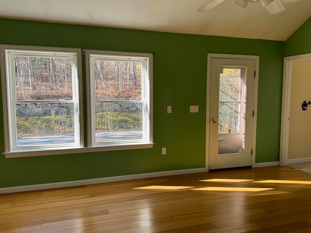 doorway to outside featuring ceiling fan, vaulted ceiling, and light hardwood / wood-style flooring