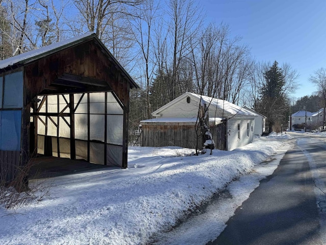 view of snow covered exterior with an outbuilding