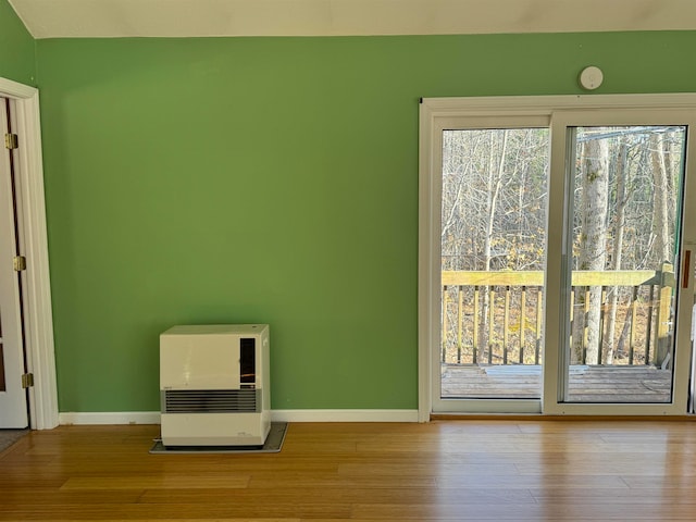 unfurnished room with heating unit and light wood-type flooring