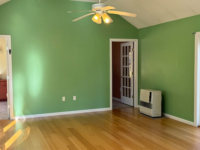 unfurnished room with ceiling fan, light wood-type flooring, heating unit, and vaulted ceiling