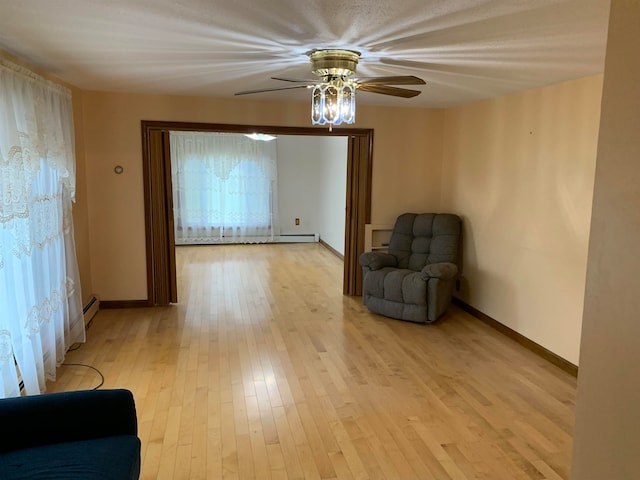 unfurnished room with a baseboard radiator, light hardwood / wood-style floors, and ceiling fan