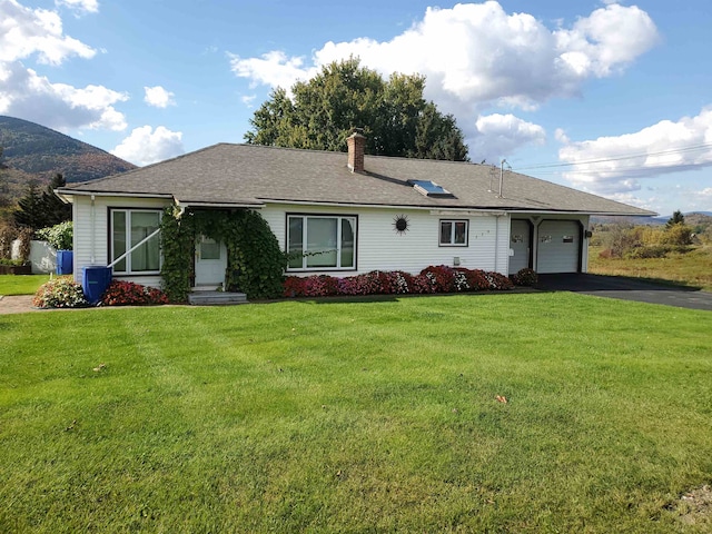 ranch-style house featuring a front lawn and a garage