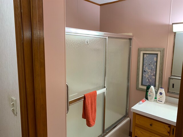 bathroom with bath / shower combo with glass door and vanity