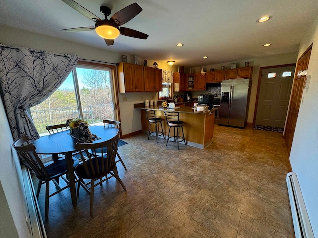 dining space featuring a baseboard radiator and ceiling fan