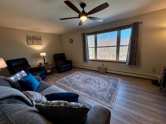 living room featuring baseboard heating, hardwood / wood-style floors, and ceiling fan