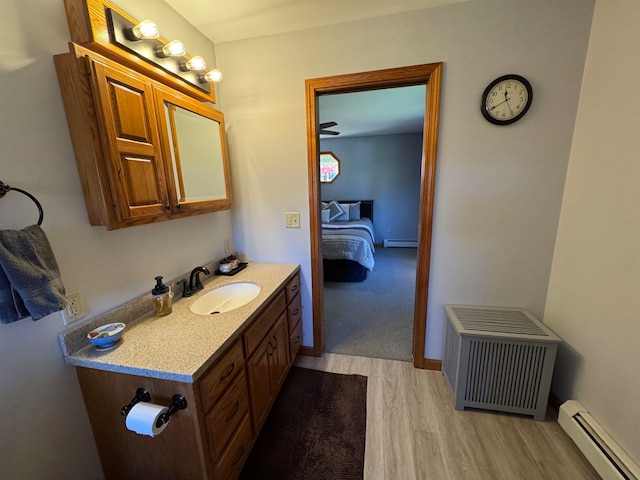 bathroom featuring vanity, wood-type flooring, and baseboard heating