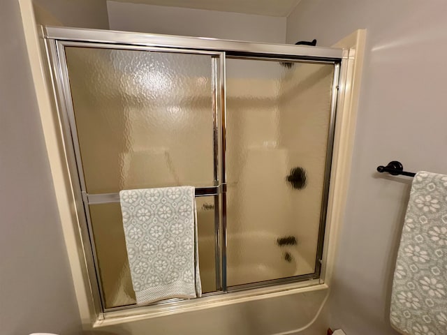 bathroom featuring bath / shower combo with glass door