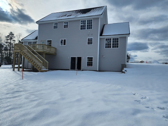 snow covered house featuring a deck