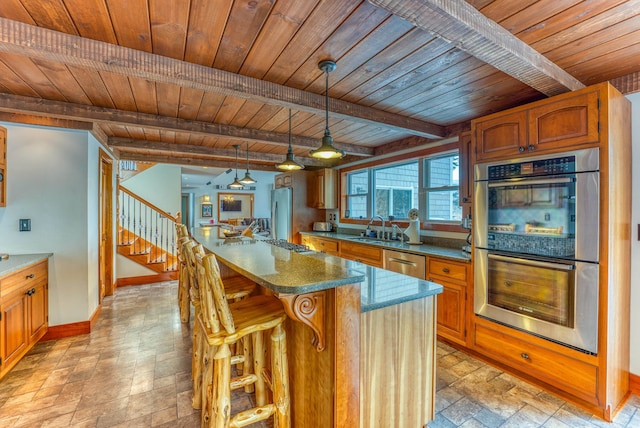 kitchen featuring stainless steel appliances, hanging light fixtures, a kitchen island, and wood ceiling