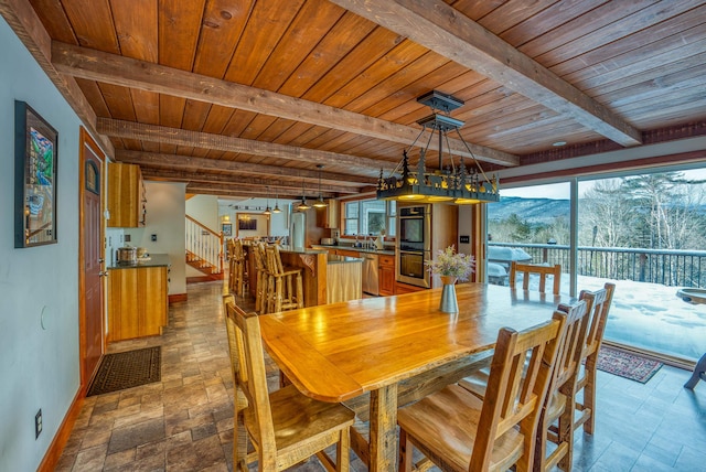 dining space featuring wooden ceiling, a mountain view, and beam ceiling