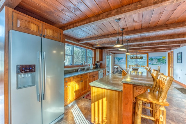 kitchen featuring stainless steel appliances, pendant lighting, light stone countertops, beamed ceiling, and wooden ceiling