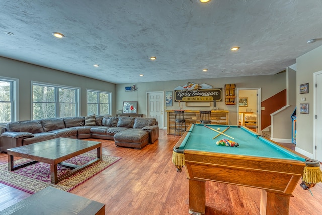 rec room with pool table, hardwood / wood-style flooring, a textured ceiling, and a healthy amount of sunlight