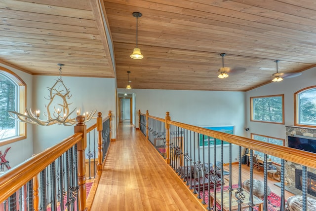 hallway with wood ceiling, wood-type flooring, vaulted ceiling, and an inviting chandelier