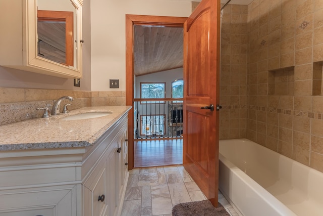 bathroom featuring tile walls, vanity, and tiled shower / bath