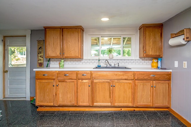 kitchen featuring wood walls, a healthy amount of sunlight, sink, and crown molding