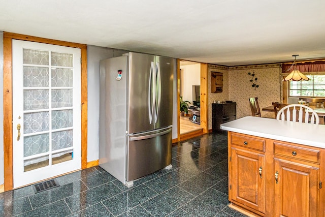 kitchen with hanging light fixtures and stainless steel refrigerator