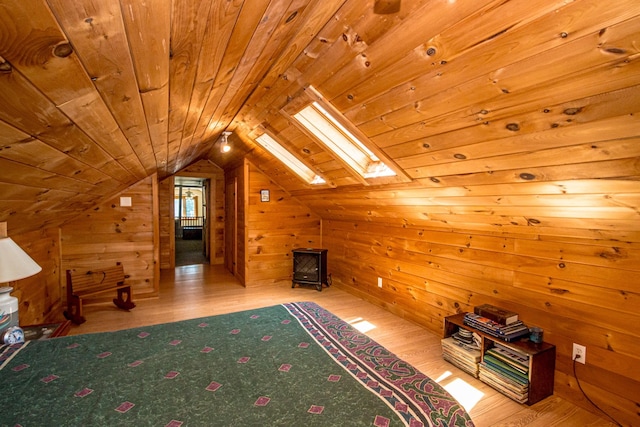 bonus room with light wood-type flooring, wooden walls, vaulted ceiling with skylight, and wooden ceiling