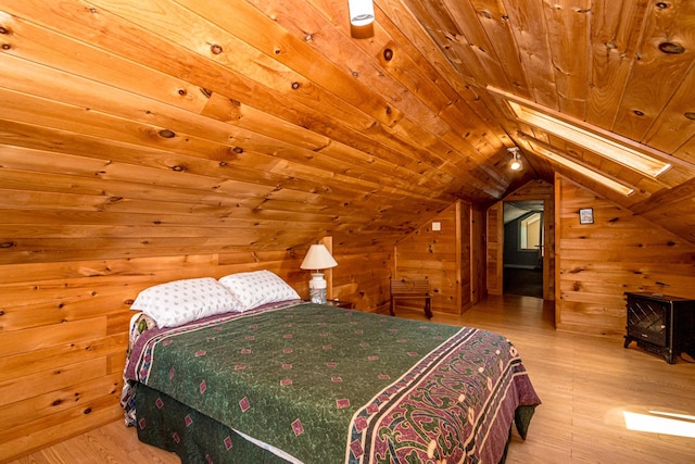 bedroom with wooden ceiling, light hardwood / wood-style floors, wooden walls, and lofted ceiling with skylight