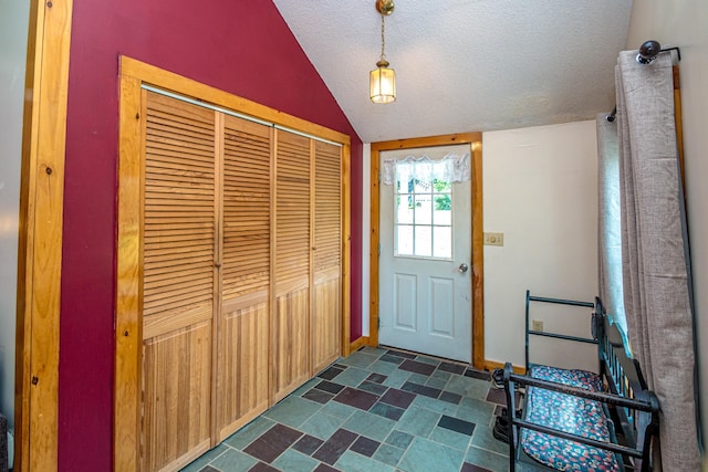 doorway featuring lofted ceiling and a textured ceiling