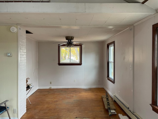 unfurnished room featuring baseboard heating, ceiling fan, a healthy amount of sunlight, and wood-type flooring