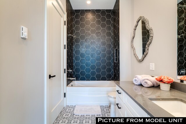 full bathroom featuring toilet, vanity, and tiled shower / bath