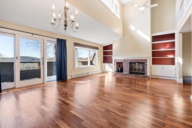 unfurnished living room with hardwood / wood-style floors, a healthy amount of sunlight, and a brick fireplace