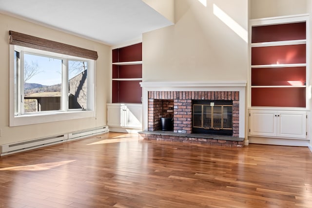 unfurnished living room with built in shelves, hardwood / wood-style floors, a baseboard radiator, and a fireplace