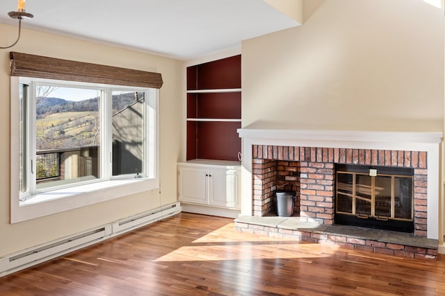 unfurnished living room featuring a fireplace, a baseboard radiator, and wood-type flooring