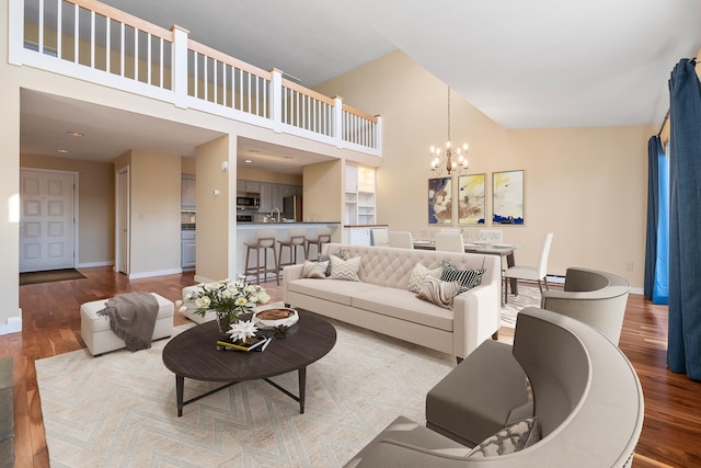 living room featuring hardwood / wood-style floors, high vaulted ceiling, and an inviting chandelier