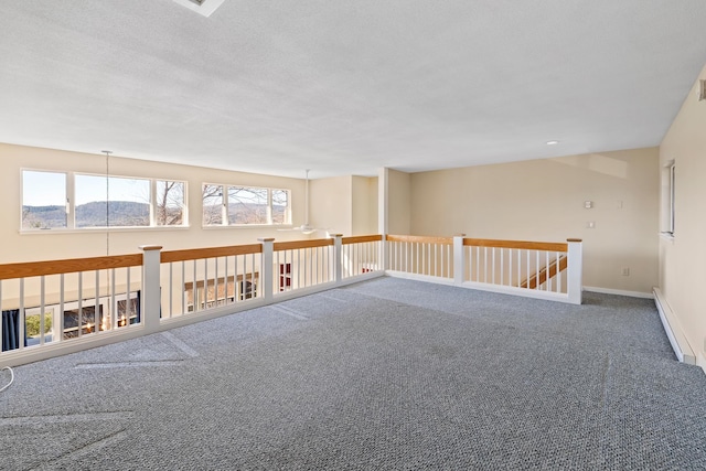 carpeted empty room featuring a baseboard radiator and a textured ceiling