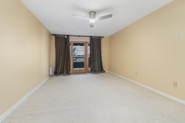 spare room with light colored carpet and ceiling fan