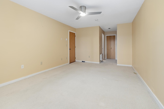 spare room with ceiling fan and light carpet