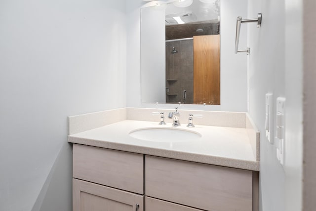 bathroom featuring vanity and tiled shower