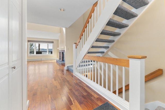 interior space with wood-type flooring and a baseboard heating unit