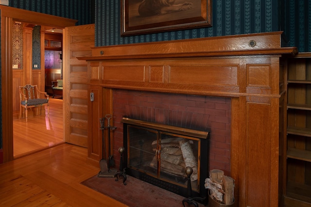 details featuring hardwood / wood-style flooring and a brick fireplace