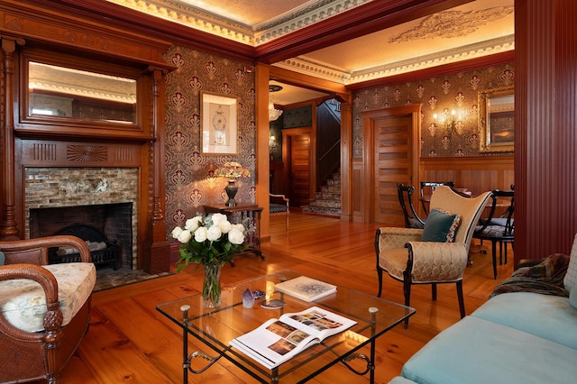 living room with hardwood / wood-style floors, a high end fireplace, a textured ceiling, and crown molding