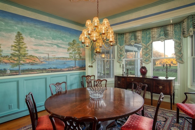 dining room featuring an inviting chandelier, hardwood / wood-style floors, crown molding, and a baseboard heating unit