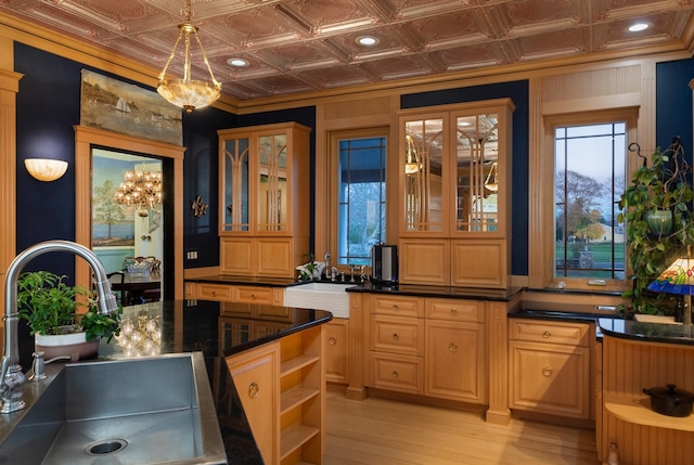 bar featuring light hardwood / wood-style flooring, hanging light fixtures, sink, and plenty of natural light