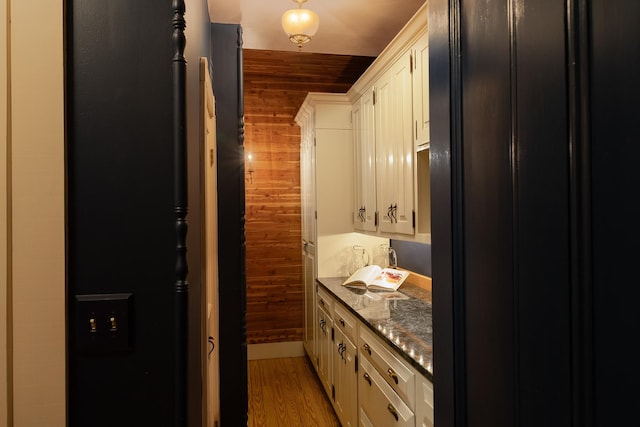 bathroom featuring vanity, wooden walls, and wood-type flooring