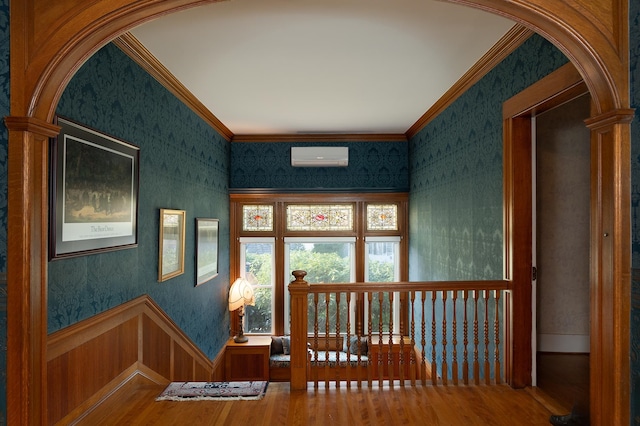 hall featuring hardwood / wood-style floors, a wall mounted air conditioner, and crown molding