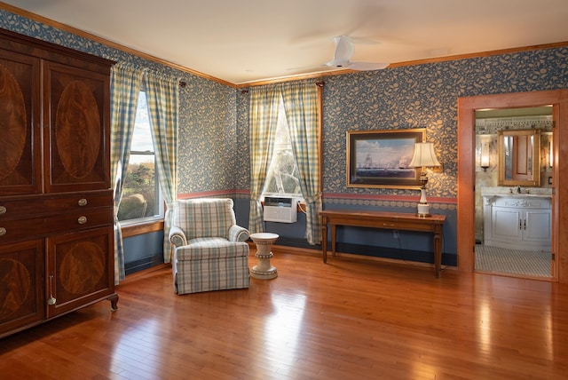 sitting room with hardwood / wood-style flooring, ceiling fan, cooling unit, and crown molding