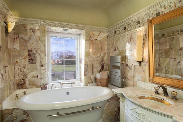 bathroom with tile walls, a bathtub, and vanity