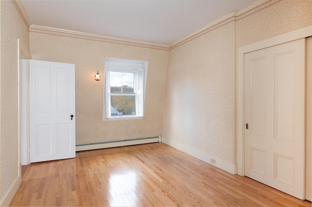 unfurnished bedroom with a baseboard radiator, light wood-type flooring, and crown molding