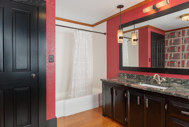 bathroom featuring wood-type flooring, vanity, crown molding, and shower / tub combo