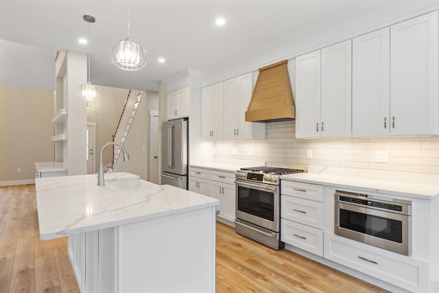 276 Sterling Dr, Laconia, NH 03246 - kitchen with appliances with stainless steel finishes, custom range hood, a sink, decorative backsplash, and light wood finished floors