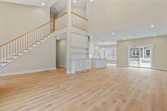 276 Sterling Dr, Laconia, NH 03246 - unfurnished living room with light wood-style floors, a chandelier, baseboards, stairs, and recessed lighting