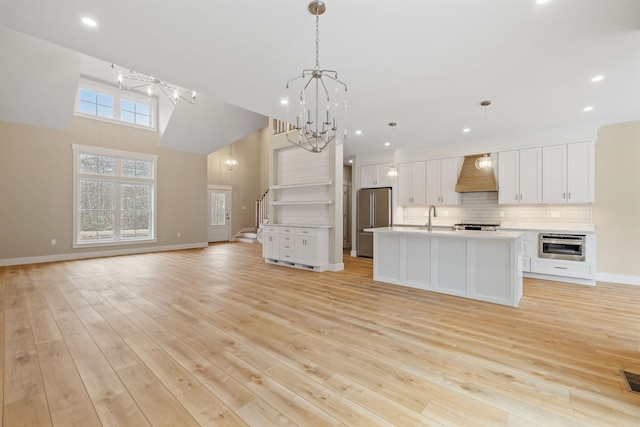 276 Sterling Dr, Laconia, NH 03246 - kitchen with stainless steel appliances, custom range hood, a chandelier, a sink, and open floor plan