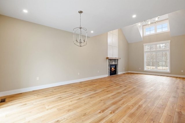 276 Sterling Dr, Laconia, NH 03246 - unfurnished living room with a chandelier, light wood-type flooring, baseboards, a stone fireplace, and recessed lighting