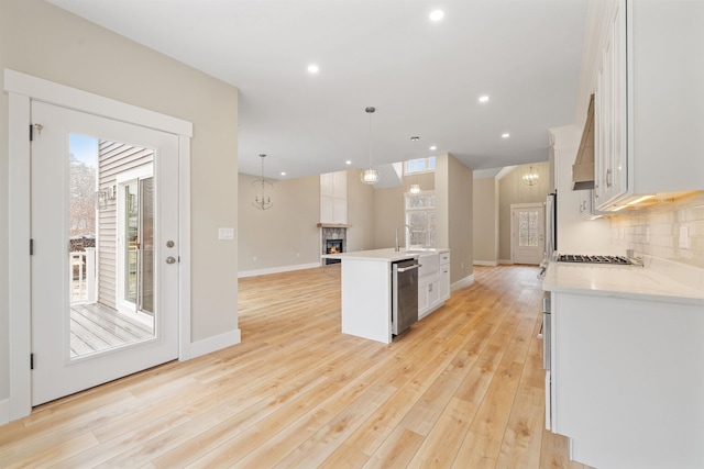 276 Sterling Dr, Laconia, NH 03246 - kitchen with white cabinets, light countertops, a kitchen island with sink, baseboards, and stainless steel appliances